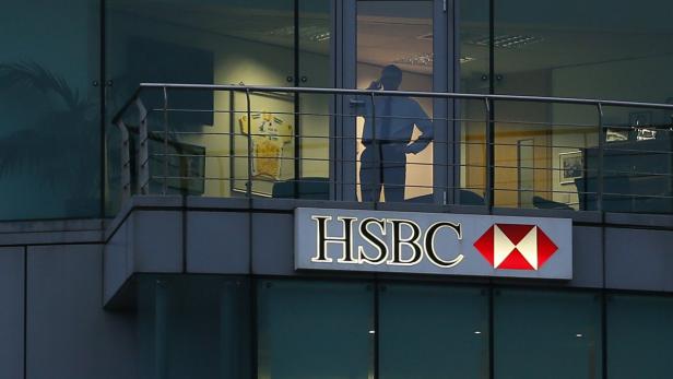 A man uses a mobile phone in a branch of HSBC in St Helier, Jersey November 12, 2012. HSBC, Europe&#039;s biggest bank, is at the centre of an investigation by British tax authorities into leaked data that a newspaper said showed it provided accounts in the tax haven of Jersey for alleged criminals. REUTERS/Stefan Wermuth (JERSEY - Tags: BUSINESS)
