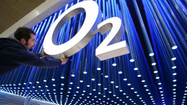 File photo of a worker making final touches to the logo of mobile phone company O2 in preparation for the CeBIT computer fair in the northern German town of Hanover March 6, 2006. Dutch telecoms group KPN announced on July 23, 2013 that will sell its German unit to Telefonica Deutschland O2 for some 8.1 billion euros ($11 billion) in cash and shares, in a long-awaited deal that will test regulators&#039; views in Europe&#039;s largest mobile market. If KPN&#039;s disposal of E-Plus is finalised, the new company would hold a share of about 30 percent of Germany&#039;s mobile service revenue and would be better armed to take on Deutsche Telekom and Vodafone, with 35 percent each. REUTERS/Christian Charisius/files (GERMANY - Tags: SCIENCE TECHNOLOGY BUSINESS TELECOMS)
