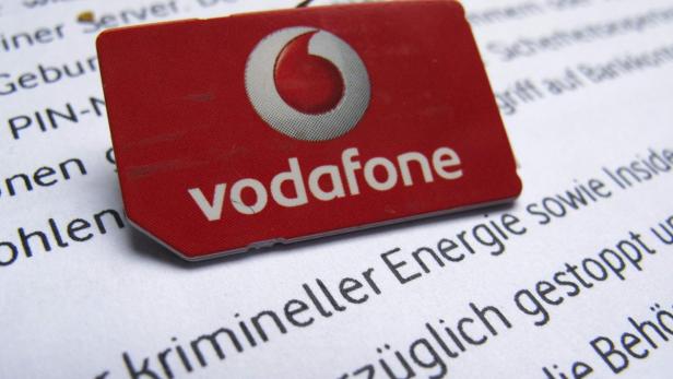 A SIM card of Vodafone is pictured in front of a letter of Vodafone Germany in Dortmund September 12, 2013. A hacker has gained access to one of Vodafone Germany&#039;s servers and has stolen the personal data of about 2 million customers, the company said on Thursday. REUTERS/Ina Fassbender (GERMANY - Tags: BUSINESS TELECOMS CRIME LAW LOGO)