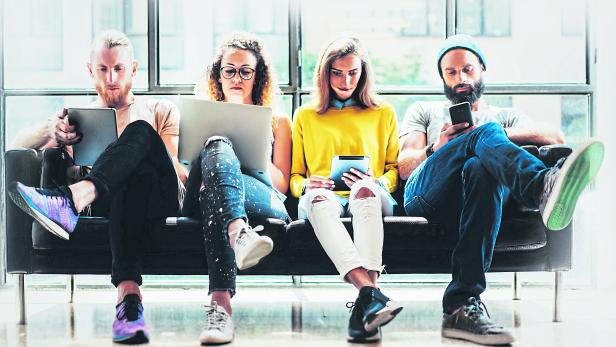 Group Adult Hipsters Friends Sitting Sofa Using Modern Gadgets.Business Startup Friendship Teamwork Concept.Creative People Working Together Marketing Project.Coworking Process Office Studio.Blurred.