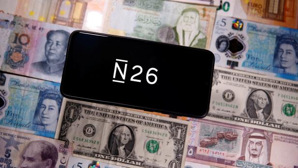 A smartphone displays a N26 logo on top of banknotes is in this illustration