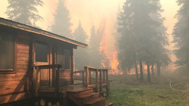 Firefighters from the Chugach National Forest work to protect the Romig Cabin on Juneau Lake from the Swan Lake Fire near Cooper Landing