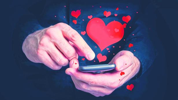 Man typing love text messages on a smartphone for Valentine's