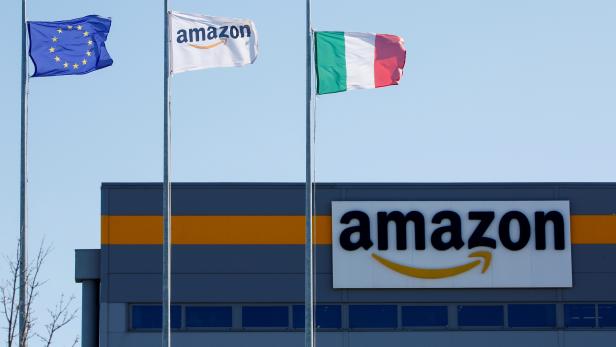 FILE PHOTO: Flags flutter outside a distribution centre, during a strike at Amazon's logistics operations in Italy, in Passo Corese, Italy