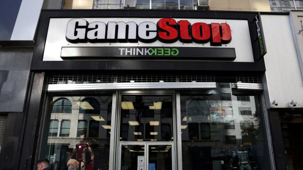 FILE PHOTO: People walk by a GameStop in Manhattan, New York
