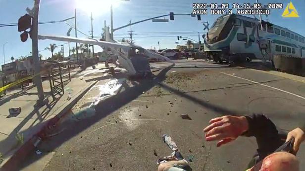 A screen grab from a police body camera video shows the pilot of a plane that crashed on railway tracks being rescued by Los Angeles Police Department officers moments before a train hit the aircraft in Los Angeles