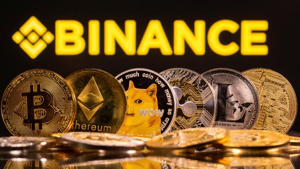 FILE PHOTO: Representations of cryptocurrencies Bitcoin, Ethereum, DogeCoin, Ripple, and Litecoin are seen in front of a displayed Binance logo