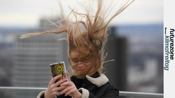 Frau nimmt Selfie von sich mit vom Wind zerzausten langen Haaren auf