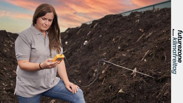 Eine Frau misst die Temperatur in einem riesigen Komposthaufen