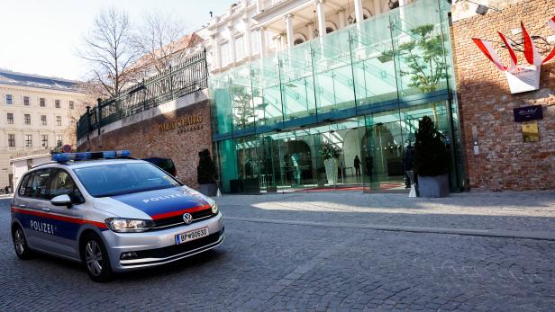 A police car passes the Palais Coburg in Vienna