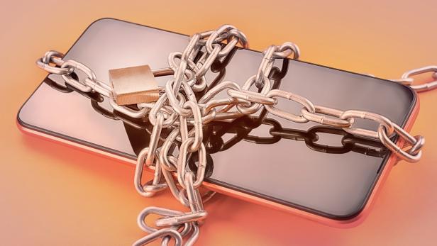 Ein Smartphone ist mit einer Kette und einem Vorhängeschloss gesichert.