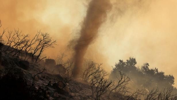 FILE PHOTO: A wildfire dubbed the Cave Fire burns in the hills of Santa Barbara, California,