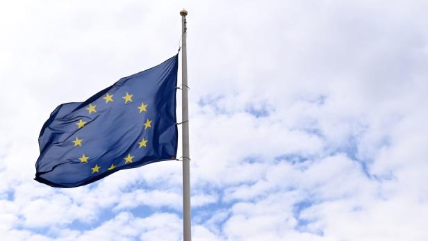 Die Europaflagge weht vor einem Himmel mit weißen Wolken.