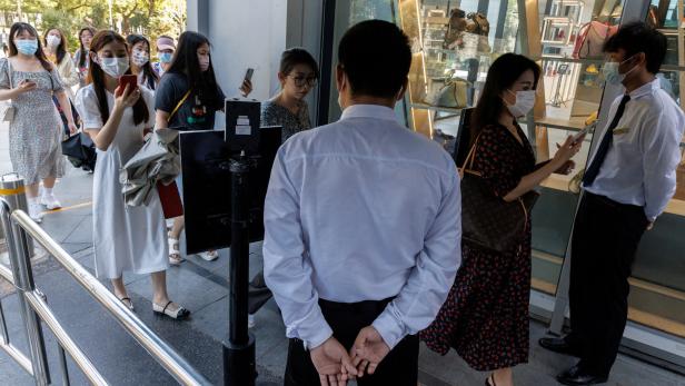 Security guards check the health code app of people entering a business area before office hours, following a coronavirus disease (COVID-19) outbreak, in Beijing
