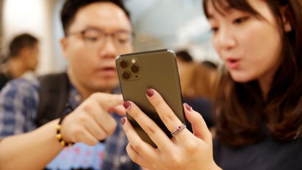 FILE PHOTO: A customer touches Apple's new iPhone 11 Pro Max after it went on sale at the Apple Store in Beijing