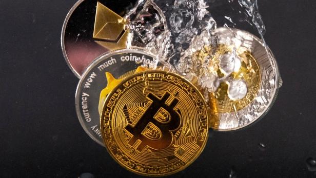 FILE PHOTO: Souvenir tokens representing cryptocurrency networks Bitcoin, Ethereum, Dogecoin and Ripple plunge into water