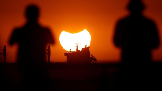 A partial solar eclipse is pictured during sunset in Vina del Mar