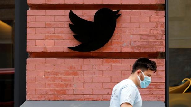 A person in a mask walks past the New York Twitter offices after they announced they will close their opened offices effective immediately in response to updated CDC guidelines during the outbreak of the coronavirus disease (COVID-19) in Manhattan