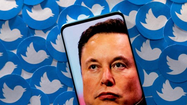 FILE PHOTO: Illustration shows Elon Musk image on smartphone and printed Twitter logos