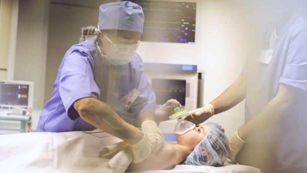 Child with oxygen mask in operating room