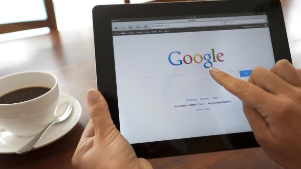Female hand holding an ipad showing Google.