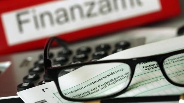 Steuererklärung mit Aktenordner und Brille