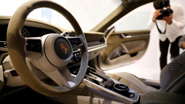 The logo of Porsche is pictured on the steering wheel of a Porsche 911 sports car on display at its dealership during a news conference in Seoul