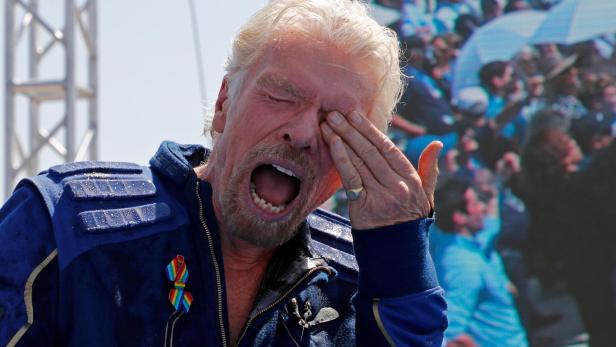Billionaire entrepreneur Richard Branson reacts from sprayed champagne at Spaceport America