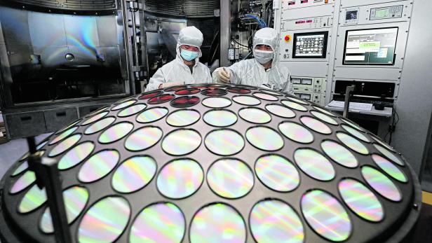 Employees work on the semiconductor chip production line of Jiangsu Azure Corp in Huaian