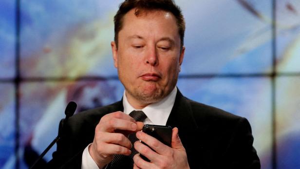 FILE PHOTO: Elon Musk looks at his mobile phone