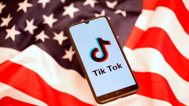 FILE PHOTO: TikTok logo is displayed on the smartphone while standing on the U.S. flag in this illustration