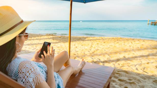 Symbolbild: E-Book-Lesen am Smartphone im Urlaub