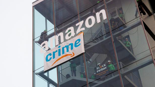 Symbolbild: Greenpeace-Aktivist*innen bringen ein "Crime"-Banner auf einem Amazon-Gebäude an.