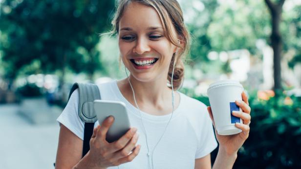 Eine Frau hört Musik am Smartphone (Symbolbild).