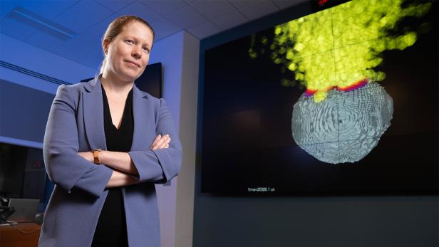 Studienleiterin Mary Burkey mit einem Standbild einer Atombombenexplosion auf einem Asteroiden