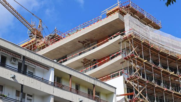 Ein Gebäude im Bau mit einem Kran im Hintergrund.