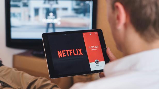 Mann  mit Tablet mit Netflix-App