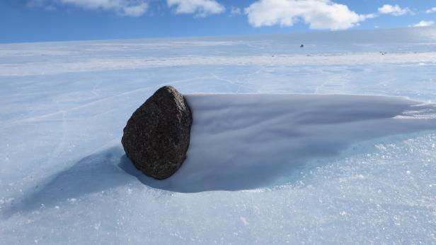 Ein schwarzer Meteorit in der Antarktis. Wegen dem Klimawandels könnten die Himmelskörper schon bald im Meer verschwinden. 