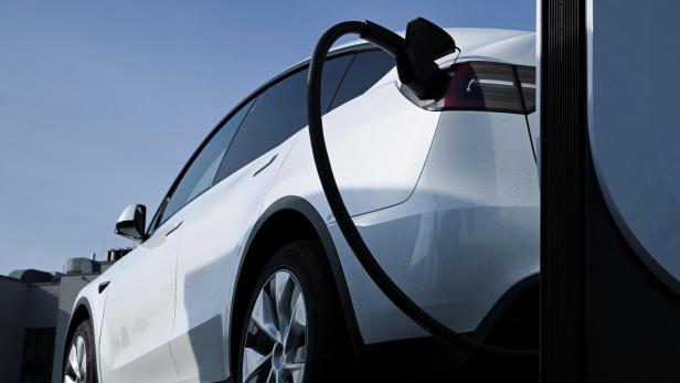 Weißes Elektroauto steckt an der Ladestation