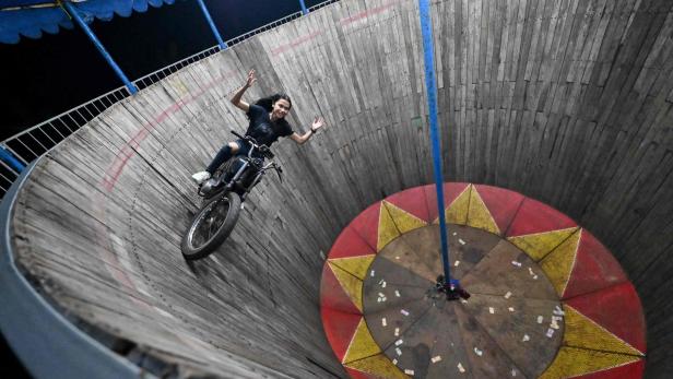 Stuntfrau auf einem Motorrad auf einer "Wall of Death"