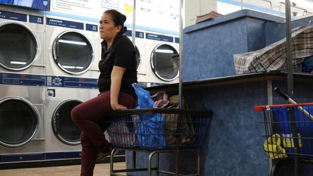 FILE PHOTO: A woman waits at a laundromat in downtown Los Angeles