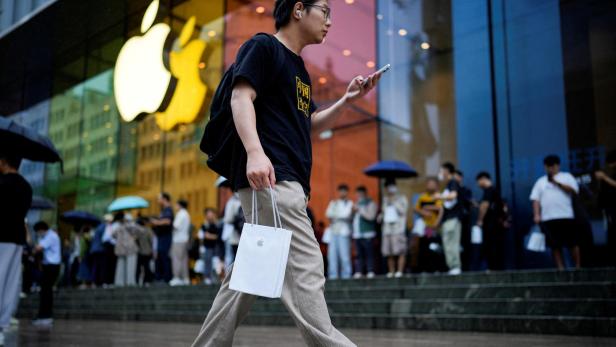 Ein Mann trägt Apples iPhone 15 in einer Tasche in Shanghai, China.