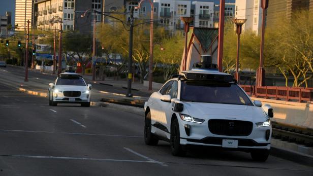 FILE PHOTO: Two Waymo autonomous vehicles drive themselves down Central Avenue in Phoenix, Arizona