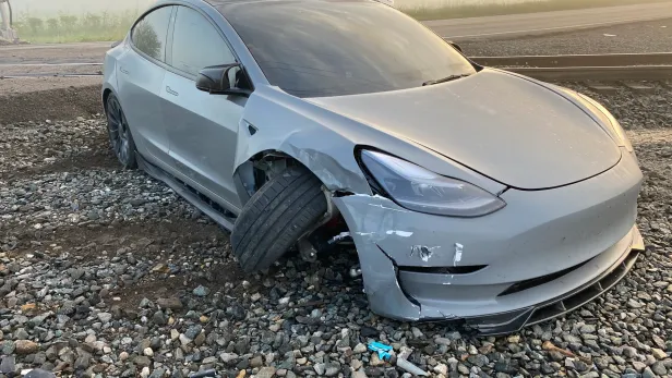 Der Tesla nach dem Unfall neben den Gleisen.