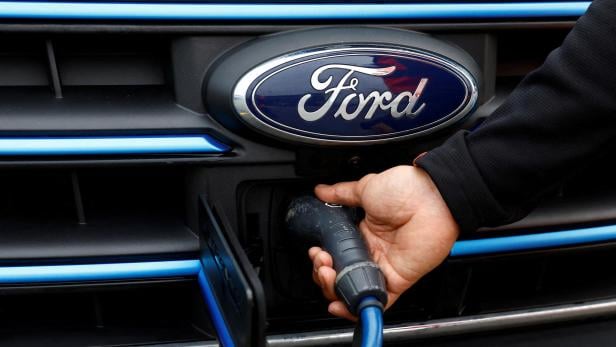 FILE PHOTO: Senior Courier for DHL, Christopher Brownbill, removes the charging cable from a Ford E-Transit in London