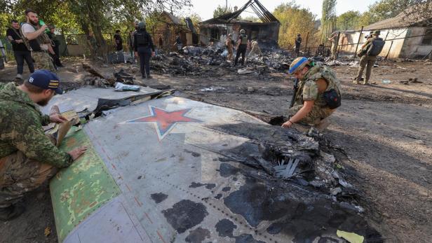 Ukrainische Soldaten inspizieren das Wrack der S-70 Okhotnik