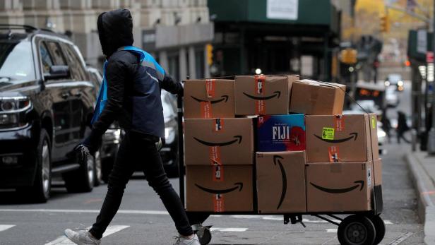 An Amazon delivery worker pulls a cart full of boxes for delivery on Cyber-Monday in New York