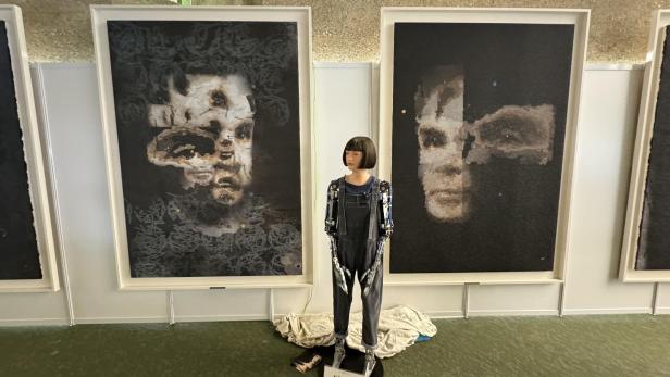 Der humanoide Roboter mit 2 Portraits von Alan Turing. Das um 1,08 Mio. US-Dollar verkaufte sieht man rechts.