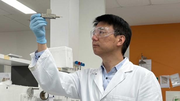 Professor Chuan Zhao mit dem Prototyp seiner Protonenbatterie.