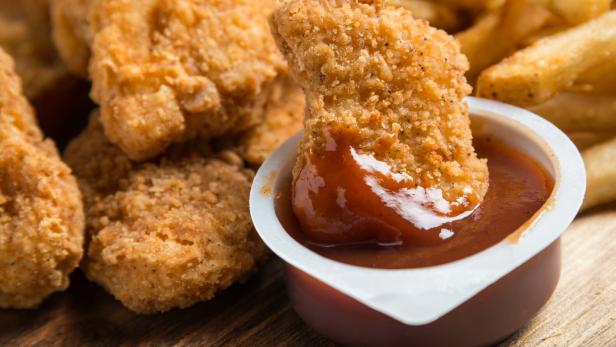 Das Stück Hendlfleisch, das das Forschungsteam der Universität von Tokio gezüchtet hat, ist etwa so groß wie ein Chicken Nugget (Symbolbild). Chicken Nuggets mit BBQ-Sauce.